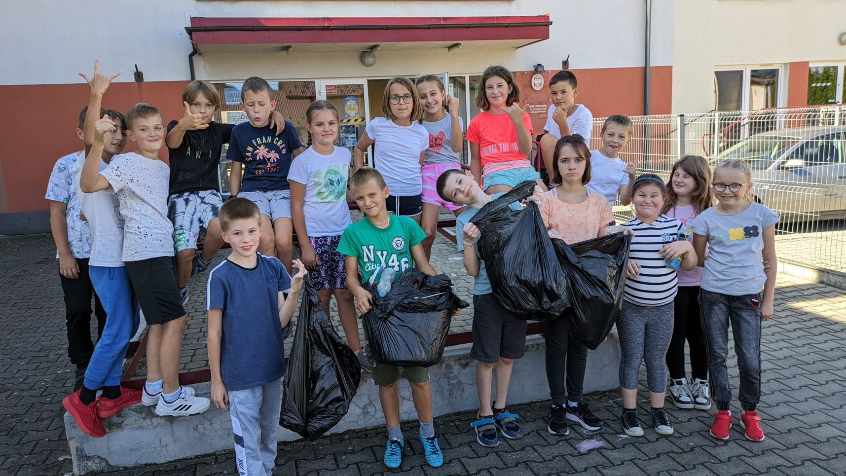 uczniowie szkoły podczas akcji sprzątania świata przed wejściem do szkoły