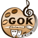 Logo GOK - paleta malarska, klucz wiolinowy i maska teatralna oraz napis GOK